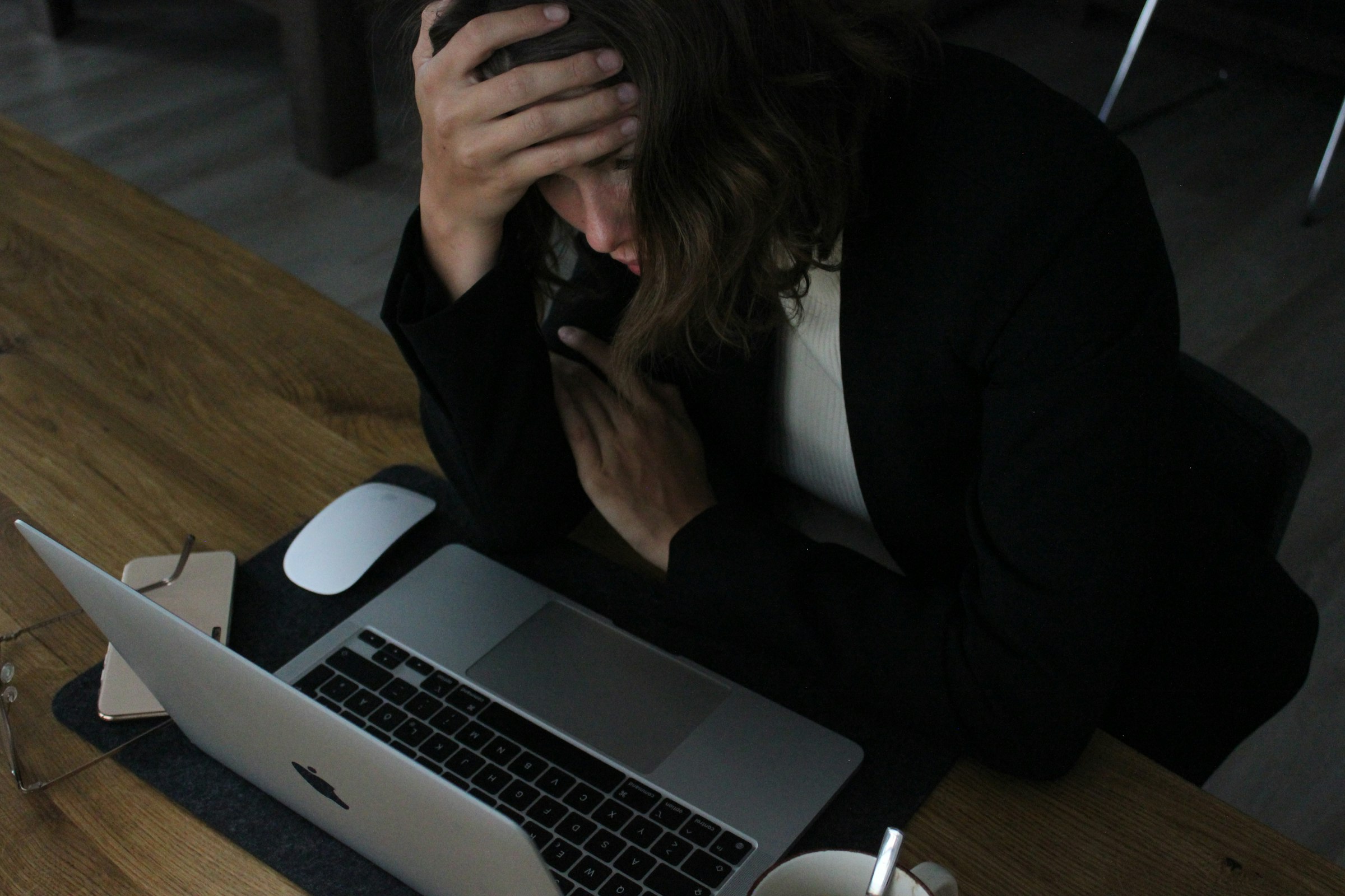 Person sitting with head down, appearing exhausted against a neutral background